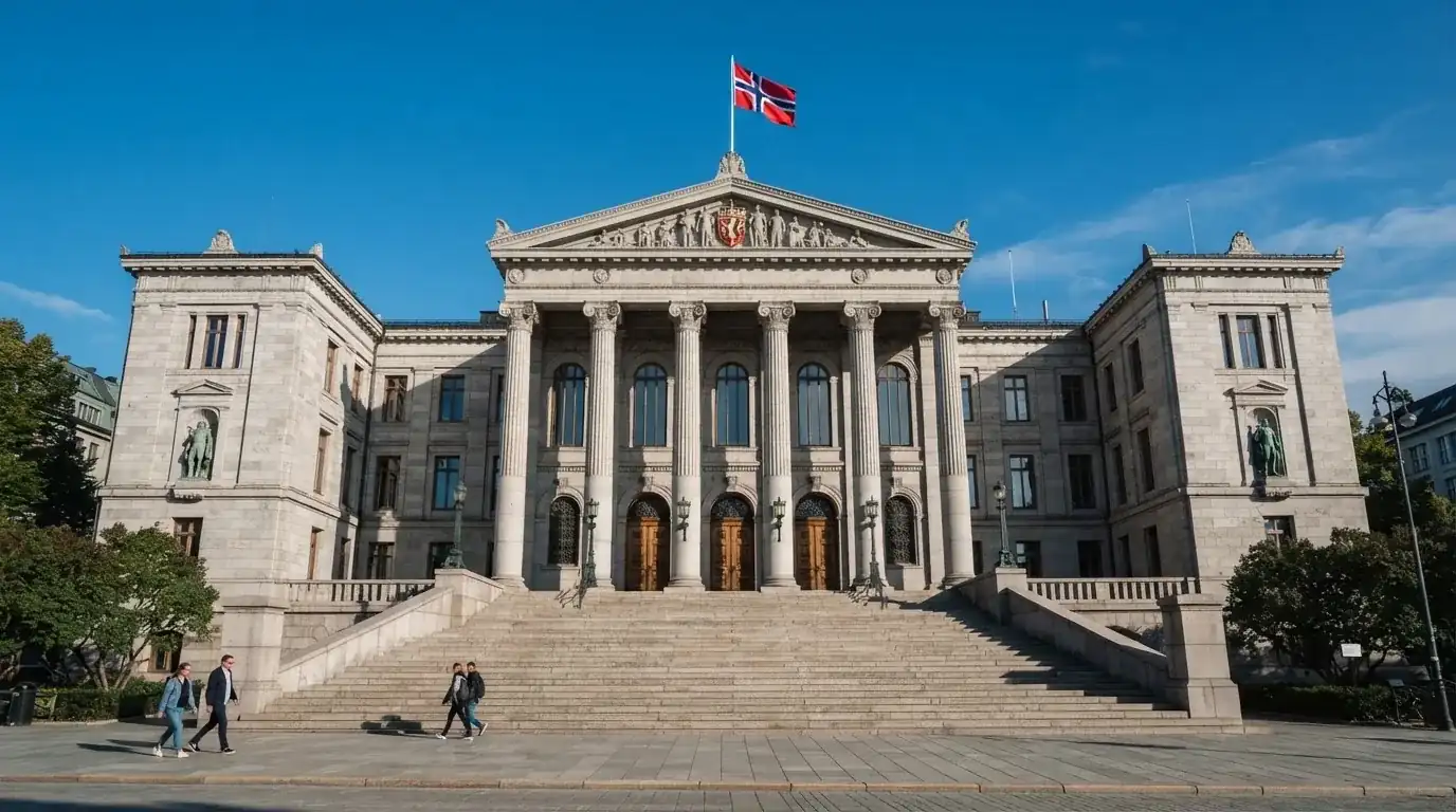Fasade av en stor offentlig bygning i Oslo med brede trapper og et norsk flagg i vinden under klar himmel